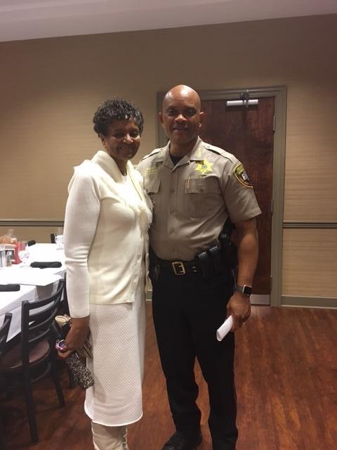 Sheriff standing with woman wearing white dress